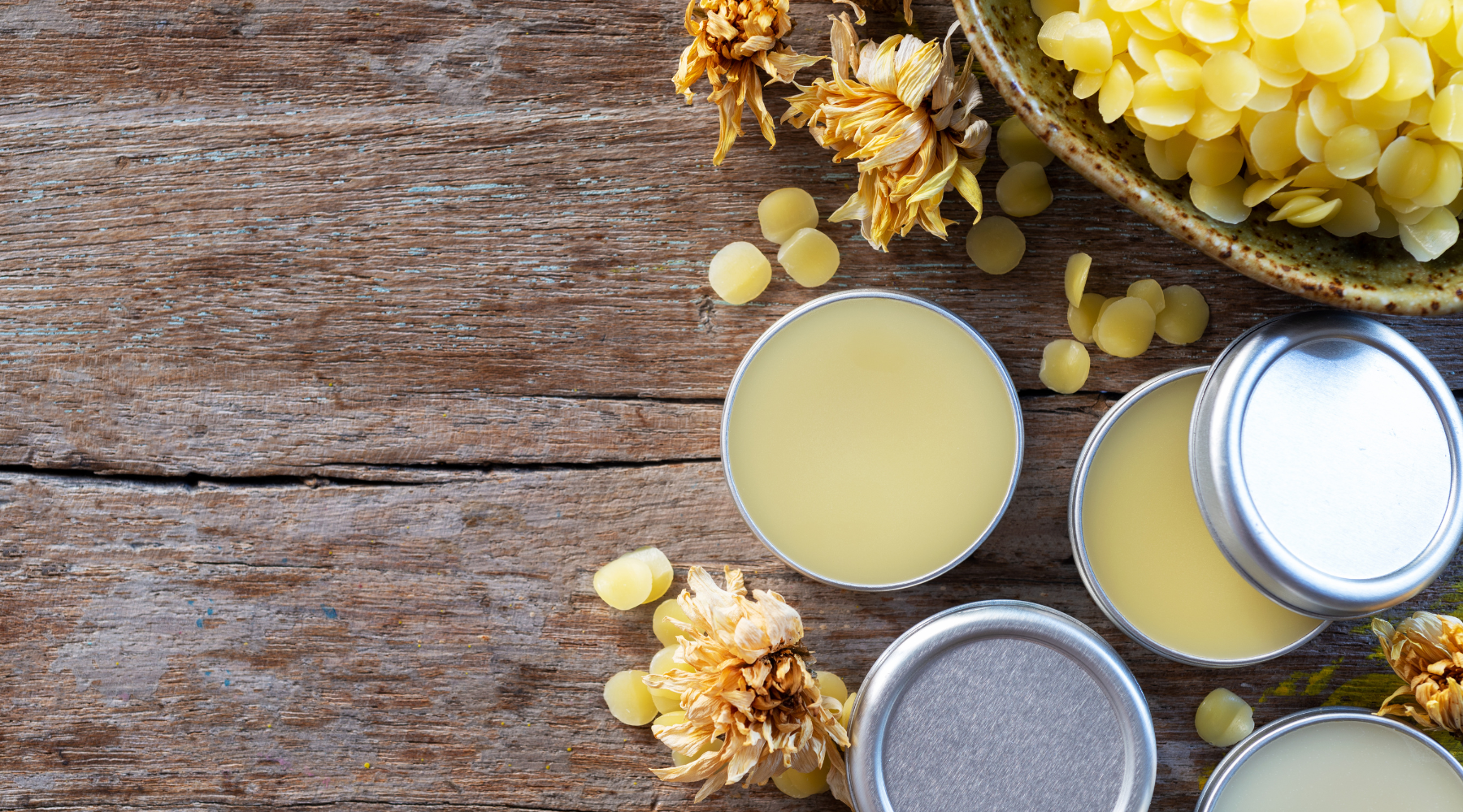 Läppbalsam i en burk och en skål bivax bredvid.